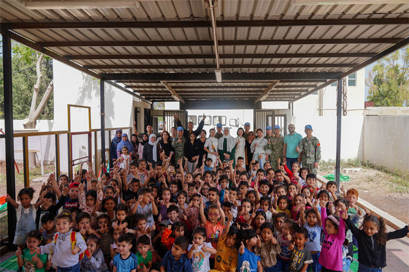 當(dāng)?shù)貢r(shí)間5月30日，黎巴嫩南部庫雷拉公立小學(xué)，“六一”國際兒童節(jié)前夕，中國第21批赴黎維和多功能工兵分隊(duì)官兵看望慰問學(xué)校師生，并開展文化交流活動，圖為我維和官兵同師生合影。李竹林?jǐn)z