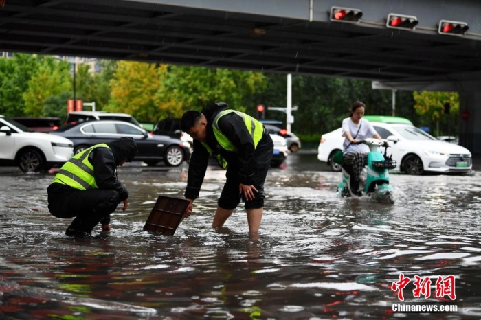 7月30日，河北省持續發布暴雨紅色預警信號。受今年第5號臺風“杜蘇芮”殘余環流影響，7月28日以來，地處華北地區的河北省大部出現降雨。30日17時，該省氣象臺發布當日第三次暴雨紅色預警信號。石家莊市城區不少區域積水嚴重，城管、環衛、園林、市政等部門緊急出動，聯合疏堵保暢，筑牢防汛安全屏障。圖為石家莊裕華區城管局防汛隊員對沿街收水井進行雜物清理，以保證排水暢通。翟羽佳 攝