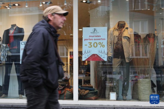   10月31日，一名男子從比利時(shí)布魯塞爾一家貼有打折信息的店鋪前走過。新華社記者 趙丁喆 攝