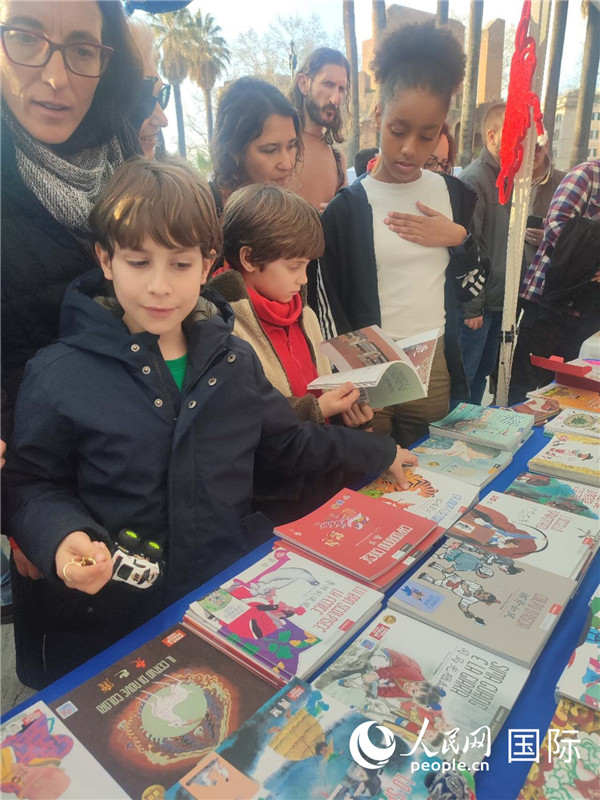 印刷精美的中國傳統文化叢書吸引了小游客的注意。人民網記者鄭彬攝