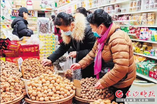 　　在長沙南門口菜市場附近的一家炒貨店內，市民正在選購年貨。　　長沙晚報全媒體記者 范宏歡 攝