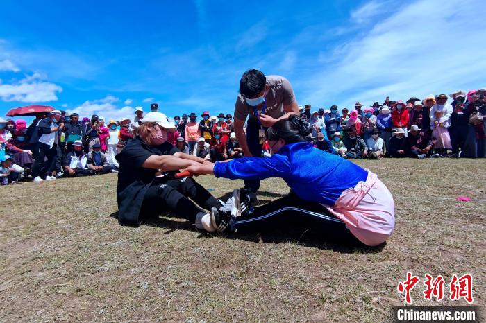 圖為當地民眾進行蹬棍比賽。　李雋 攝