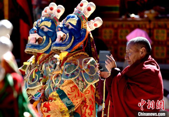 2月19日，正在拍攝跳神活動(dòng)的僧人?！±盍?攝